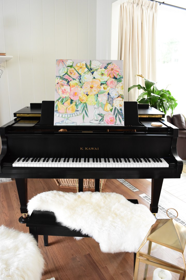 floral painting on piano with pears and white fur rug